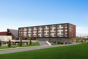 Delta Hotels offers a sleek, modern building with a brick and glass facade, featuring a flat roof and grid-patterned windows.