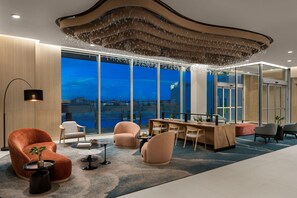 Enjoy a panoramic city view from the comfort of this stylish room, featuring a plush sofa, armchair, and dining area.