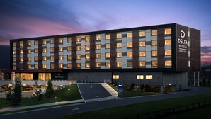 A modern hotel building with multiple floors, large windows, and a well-lit entrance.
