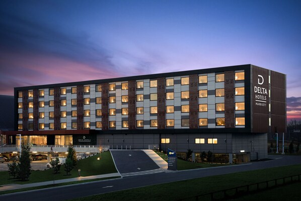 Delta Hotels features a sleek, symmetrical facade with evenly spaced windows and a covered entrance.