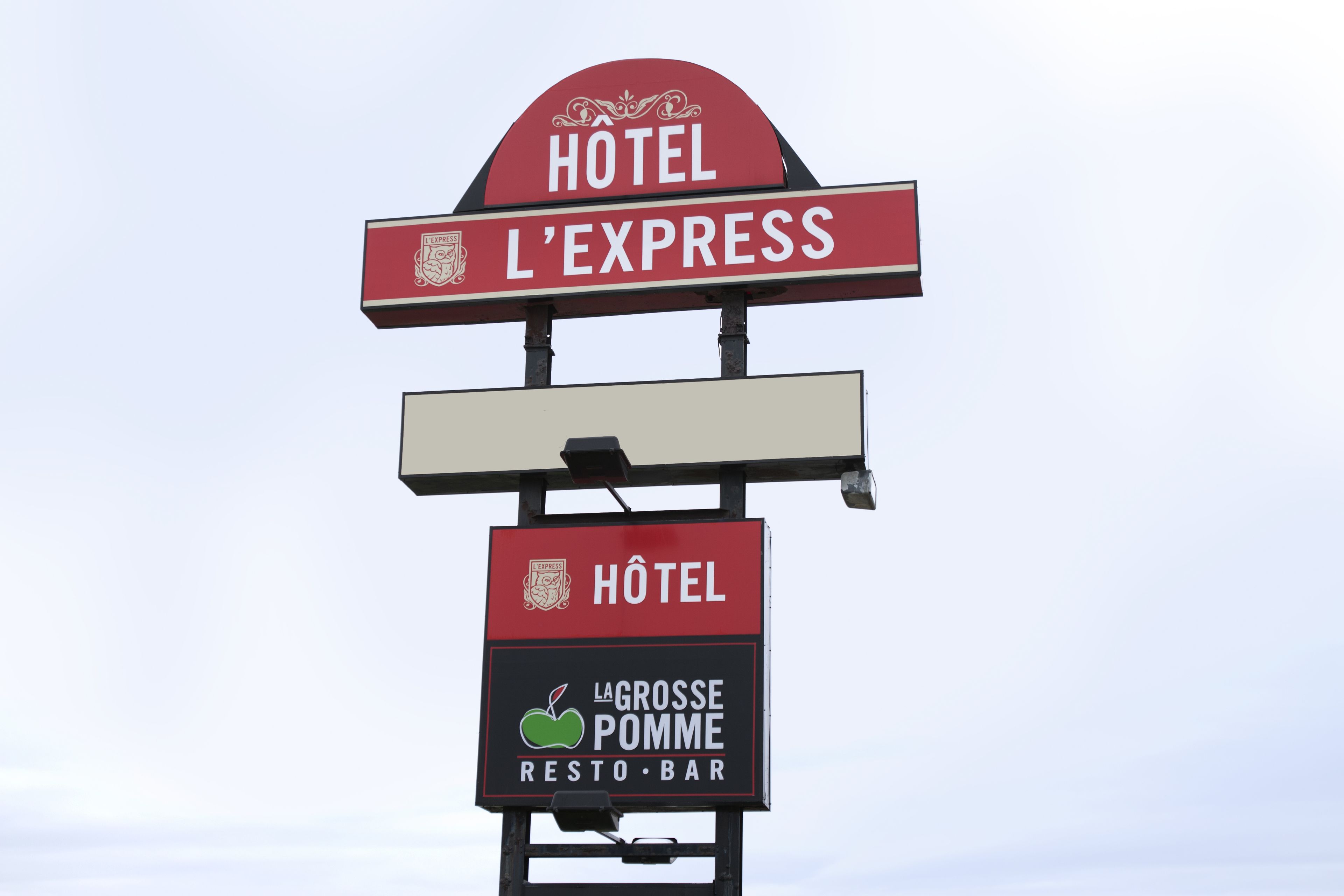 A hotel sign with 'HOTEL L'EXPRESS' and 'LA GROSSE POMME RESTO-BAR' visible.