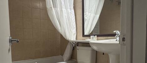 Un baño con inodoro, lavamanos y bañera.