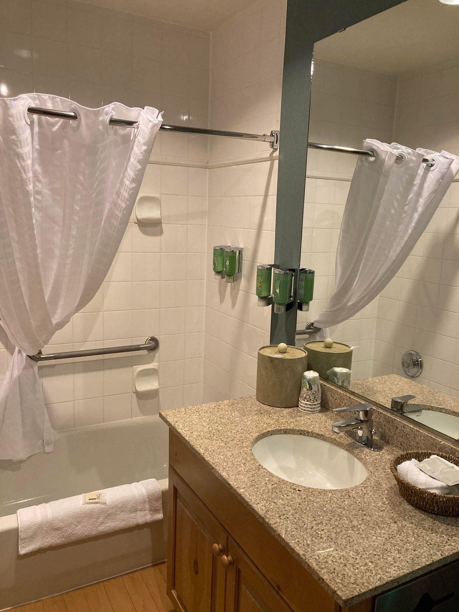 A bathroom with a bathtub, a sink, a mirror, and a shower curtain.