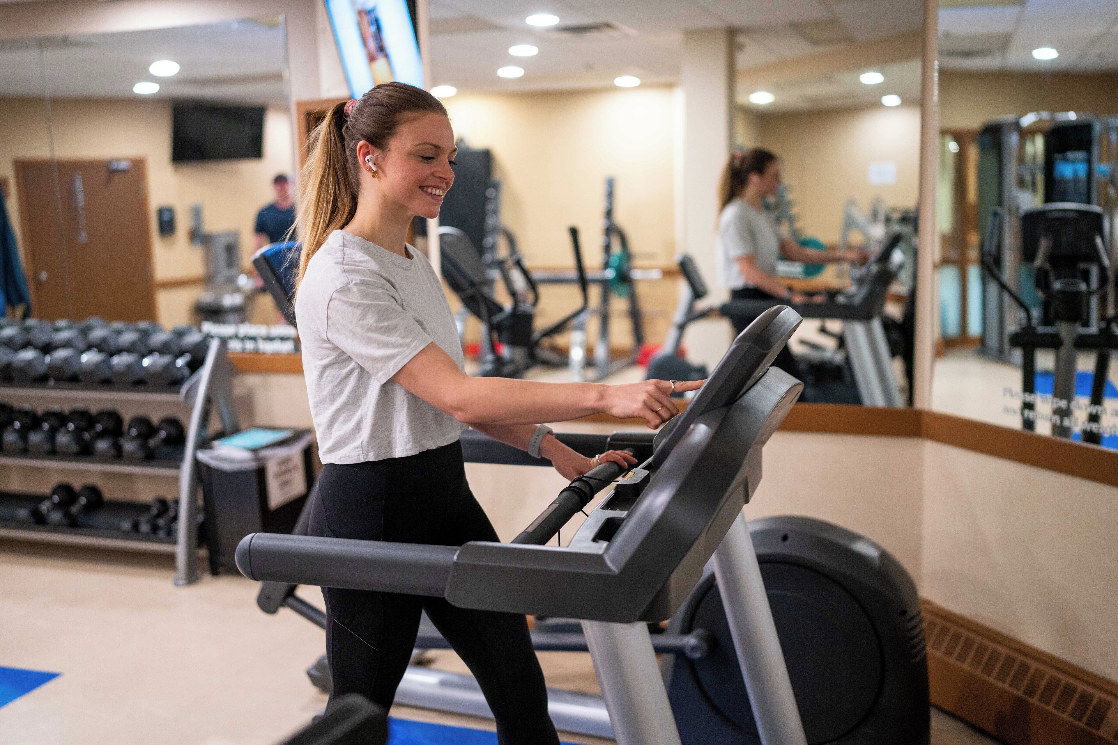 A gym with treadmills, dumbbells, and weight machines.