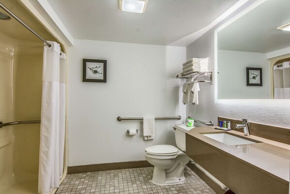 A bathroom with a toilet, sink, and shower.
