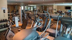 Ein Fitnessstudio mit verschiedenen Trainingsgeräten, darunter Laufbänder, Ergometer und Kraftgeräte.