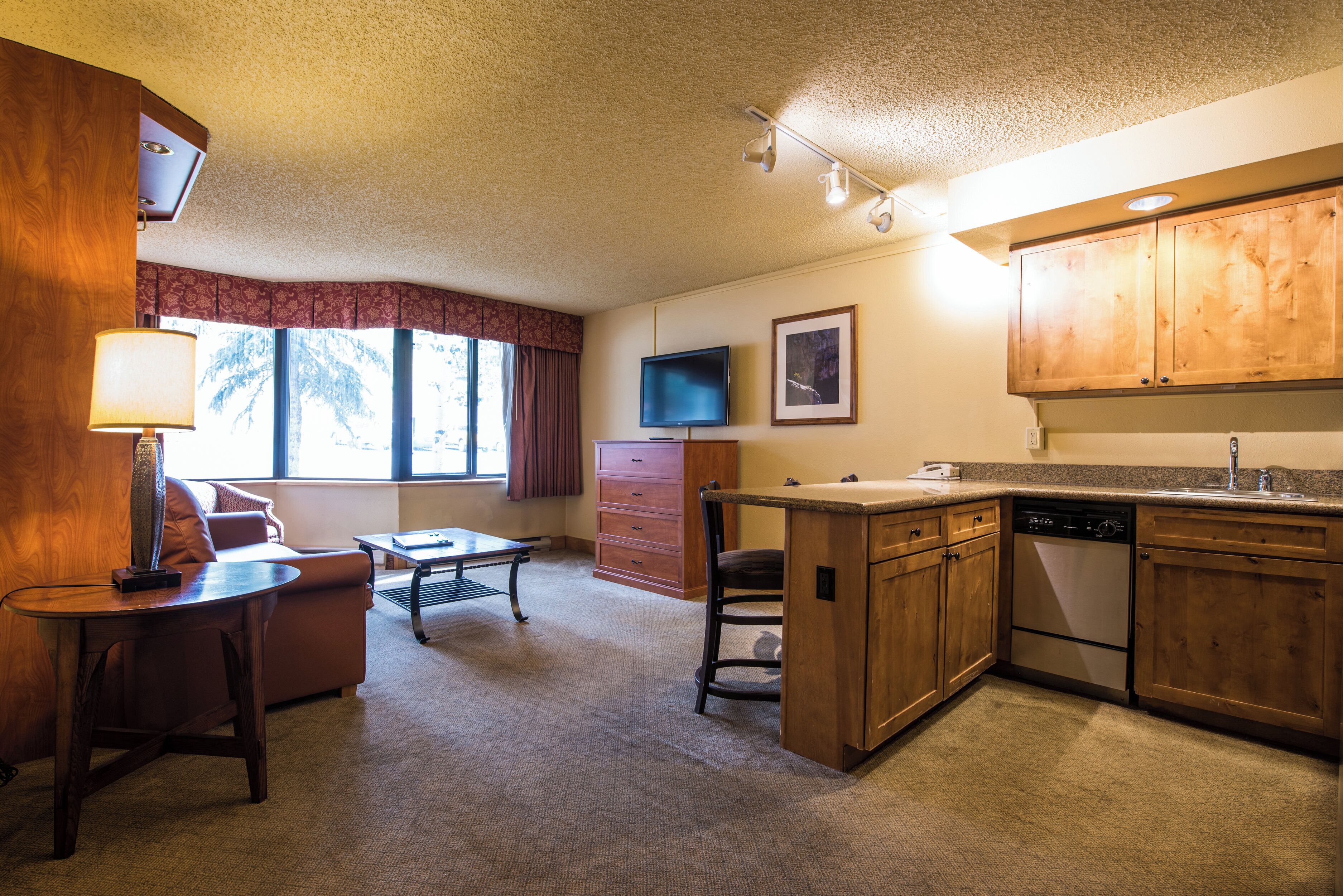 A compact living space with a kitchenette, a dining area, and a television.