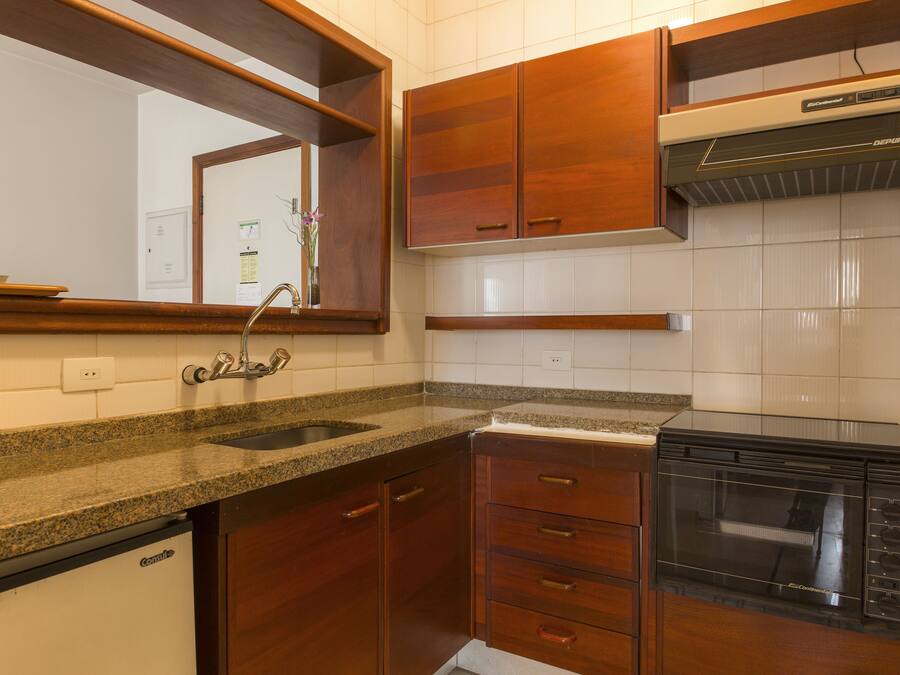 Una cocina con armarios de madera, encimera de granito, lavavajillas empotrado y microondas.