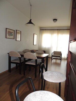 A dining area with a table and chairs, a ceiling light, and a window with curtains. - Astron St Moritz by Nobile (São Bernardo do Campo)