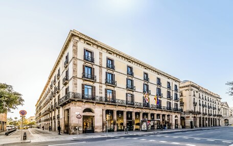 A historic building with multiple stories, large windows, and balconies.