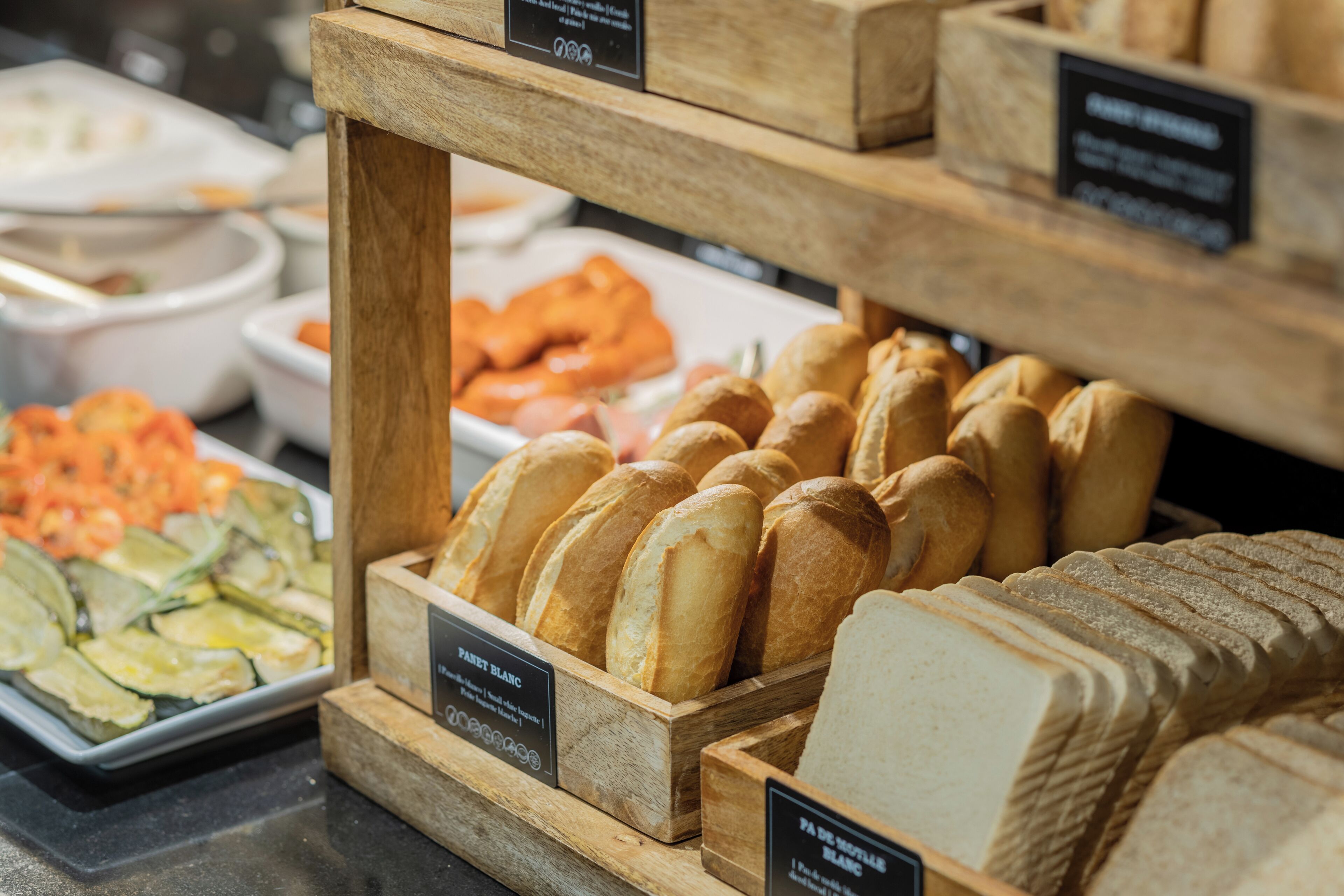 A bakery display with various types of bread and pastries.