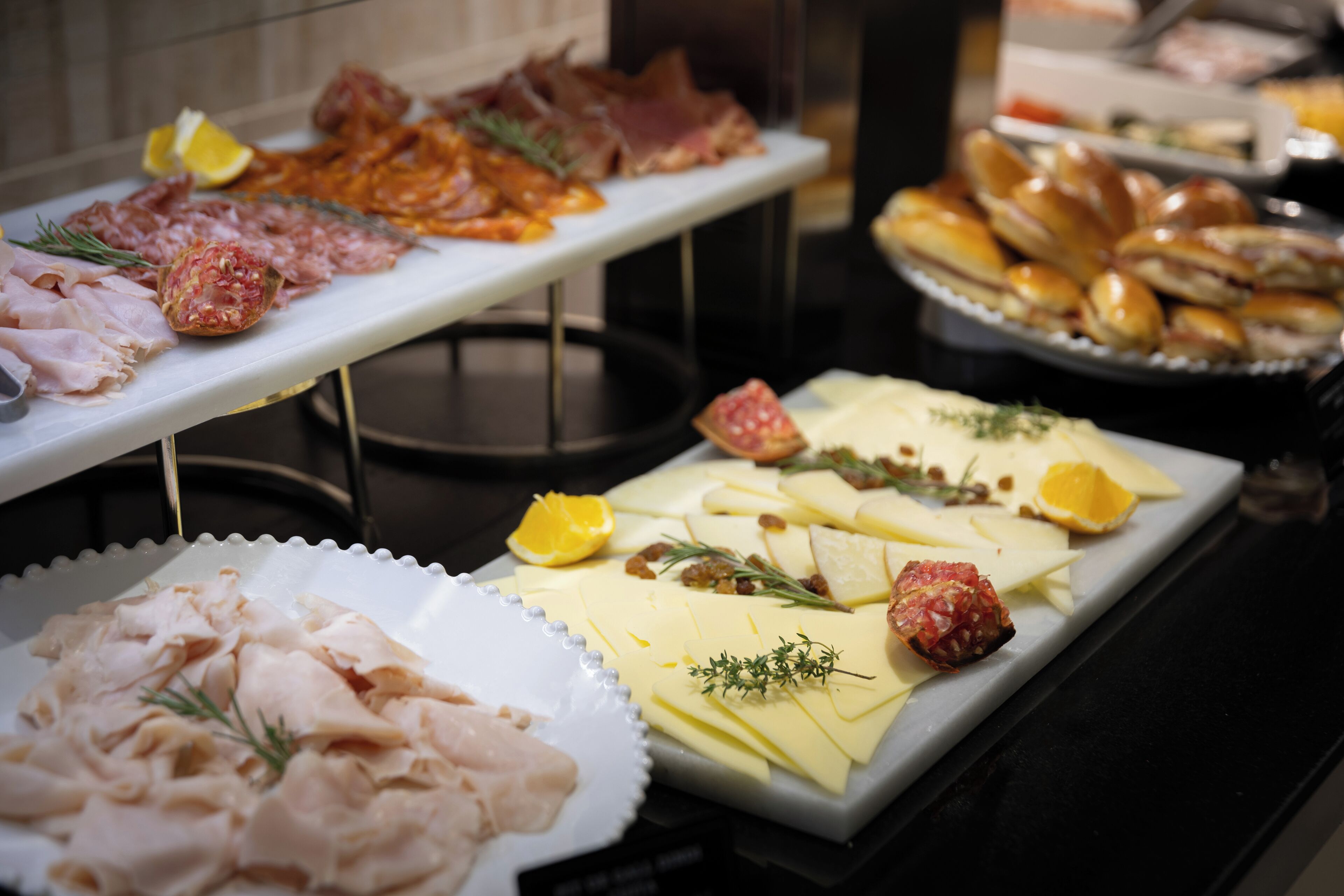 Ein reichhaltiges Buffet mit verschiedenen Speisen, darunter Fleisch, Käse und Brot.