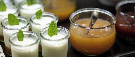 Une sélection de desserts présentés dans de petits récipients en verre, certains étant décorés d’une feuille de menthe.