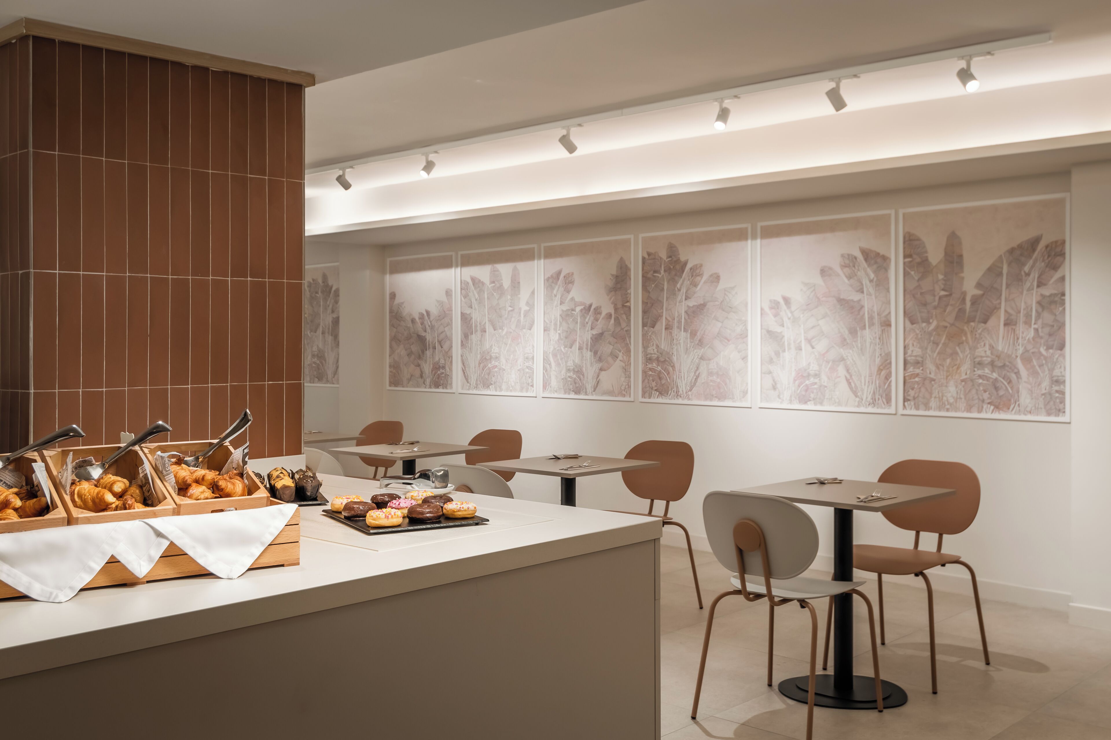 A modern dining area with a buffet counter, multiple tables, and chairs.