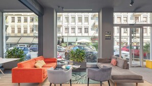A modern interior with two sofas, a coffee table, and potted plants. - B&B Hotel Milano Central Station (Milan)