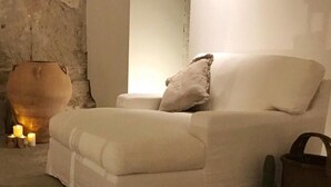 Una habitación acogedora con una zona de estar acolchada, un jarrón grande y una pequeña planta de cactus.