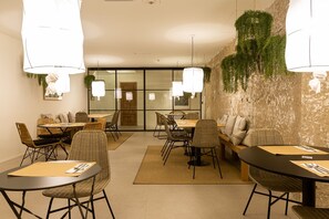 Enjoy dining in this inviting space with round and rectangular tables, wicker chairs, and cushioned benches.