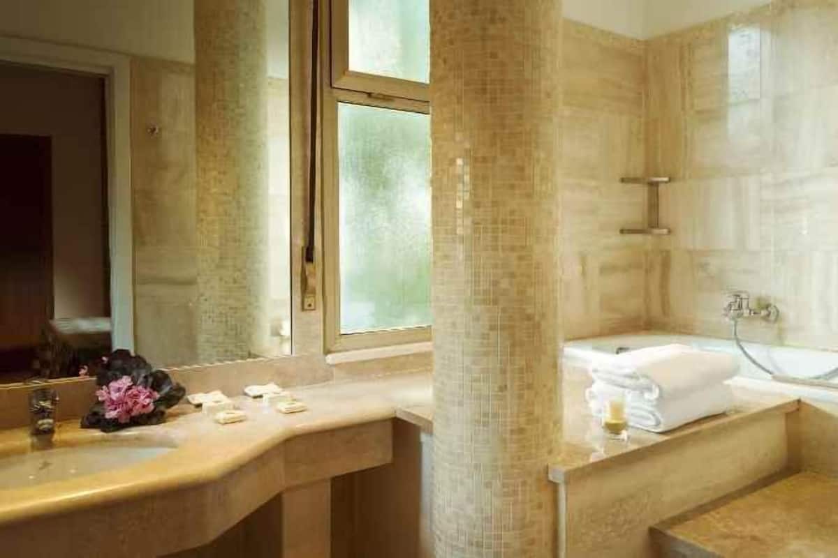 A bathroom with a bathtub, a sink, and a mirror.