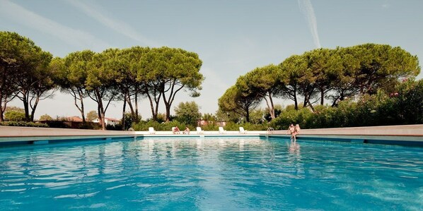 Piscine extérieure en saison, parasols, chaises longues