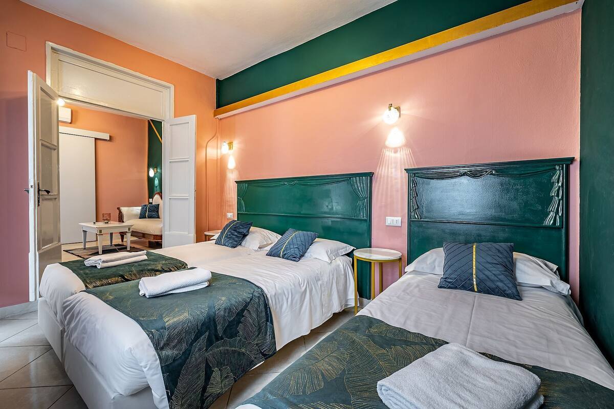 Una habitación de hotel con dos camas, una mesita y una silla.
