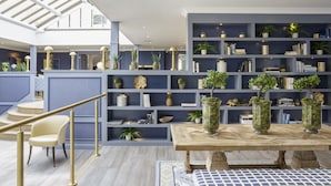 A modern interior with a wooden table, a bench, and a staircase with a golden railing. - Tewkesbury Park (Tewkesbury)