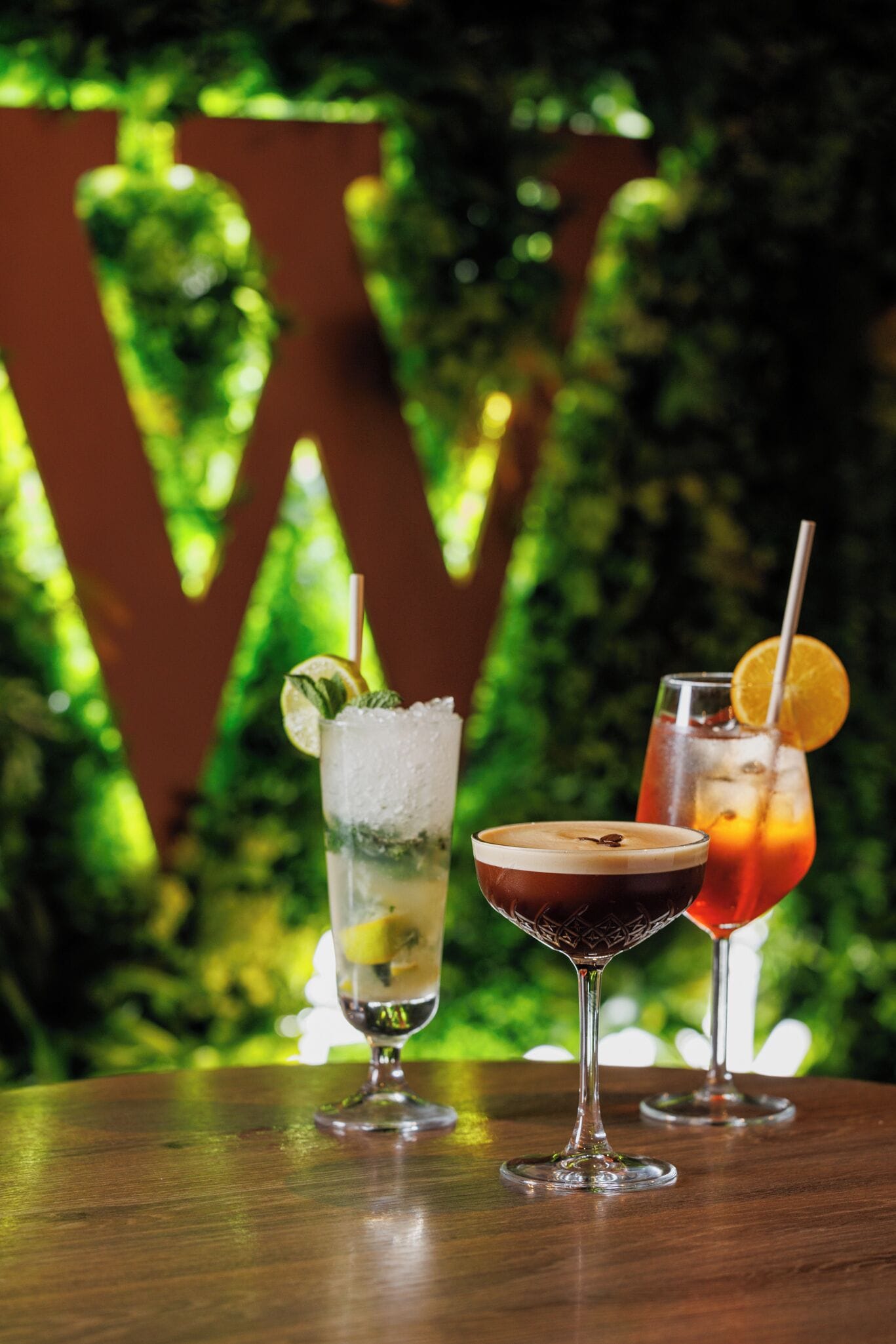 Three drinks on a wooden table with a large 'W' in the background.