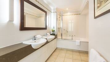 Een moderne badkamer met twee wastafels, een grote spiegel, een douche en een bad.