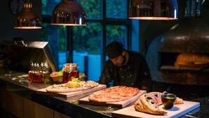 Una encimera de cocina con varias pizzas y un horno para pizza.