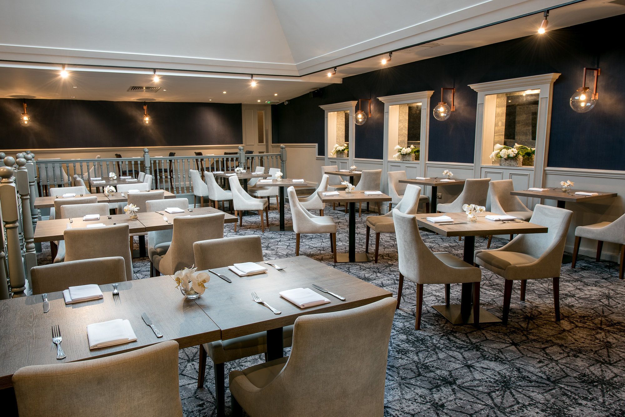 A restaurant with multiple tables and chairs, arranged in a spacious layout.