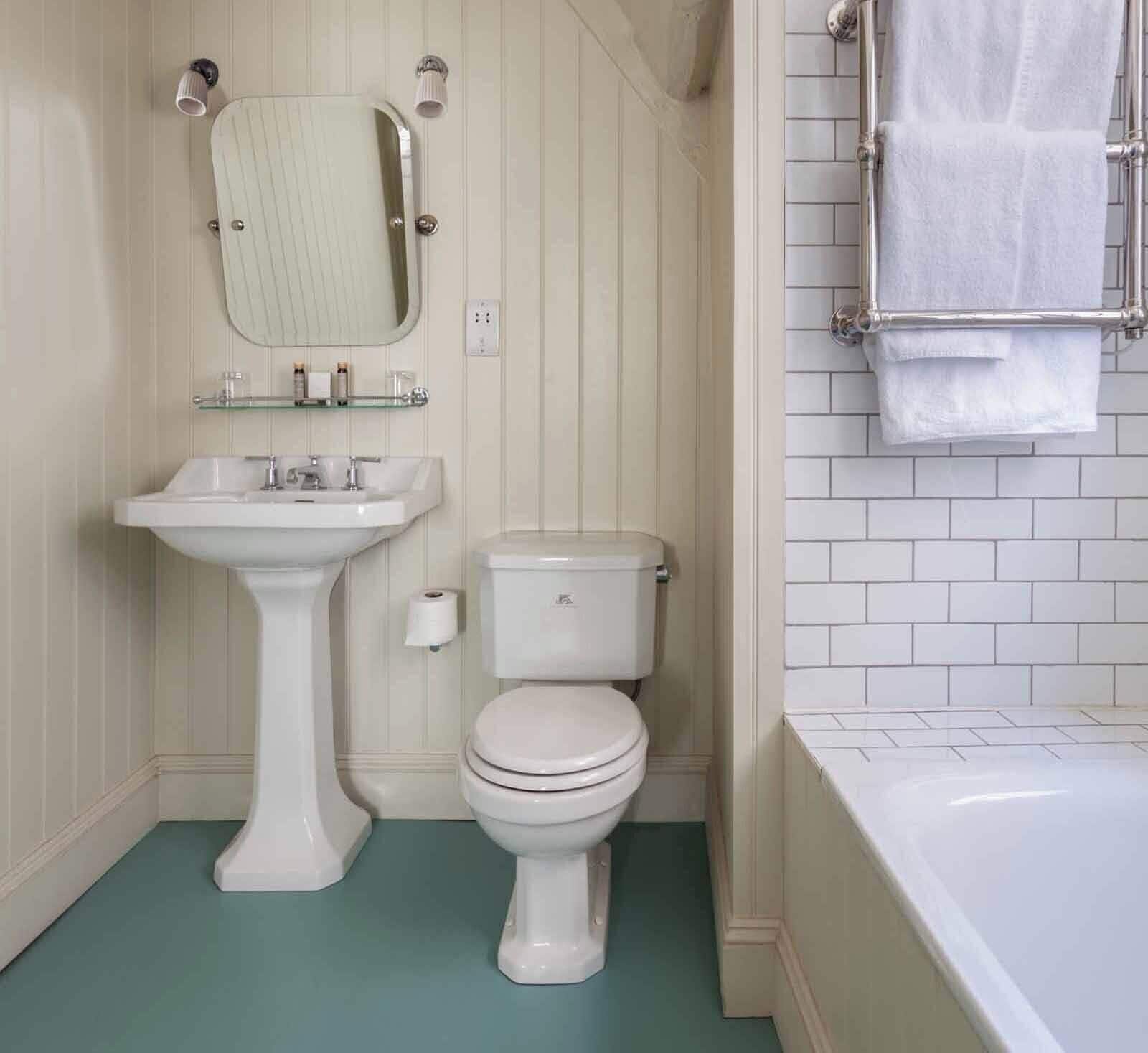 A bathroom with a pedestal sink, toilet, and bathtub.