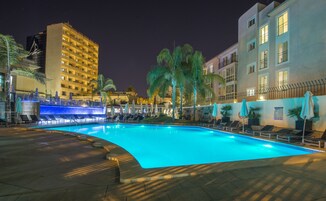 Una piscina al aire libre de temporada, sombrillas