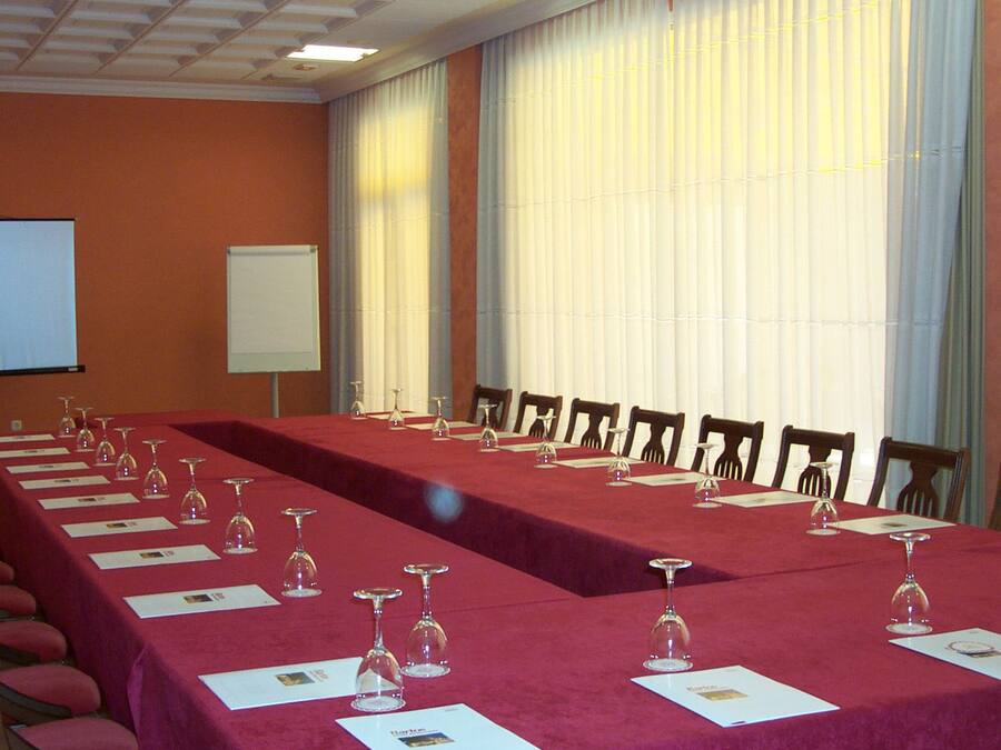 Una sala de conferencias con mesas largas, sillas y tarjetas de nombre.
