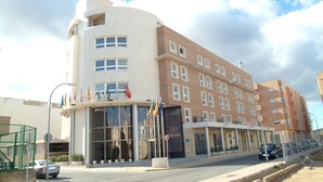 Un hotel con diseño moderno, que destaca por su fachada curva, amplias ventanas y una entrada imponente.