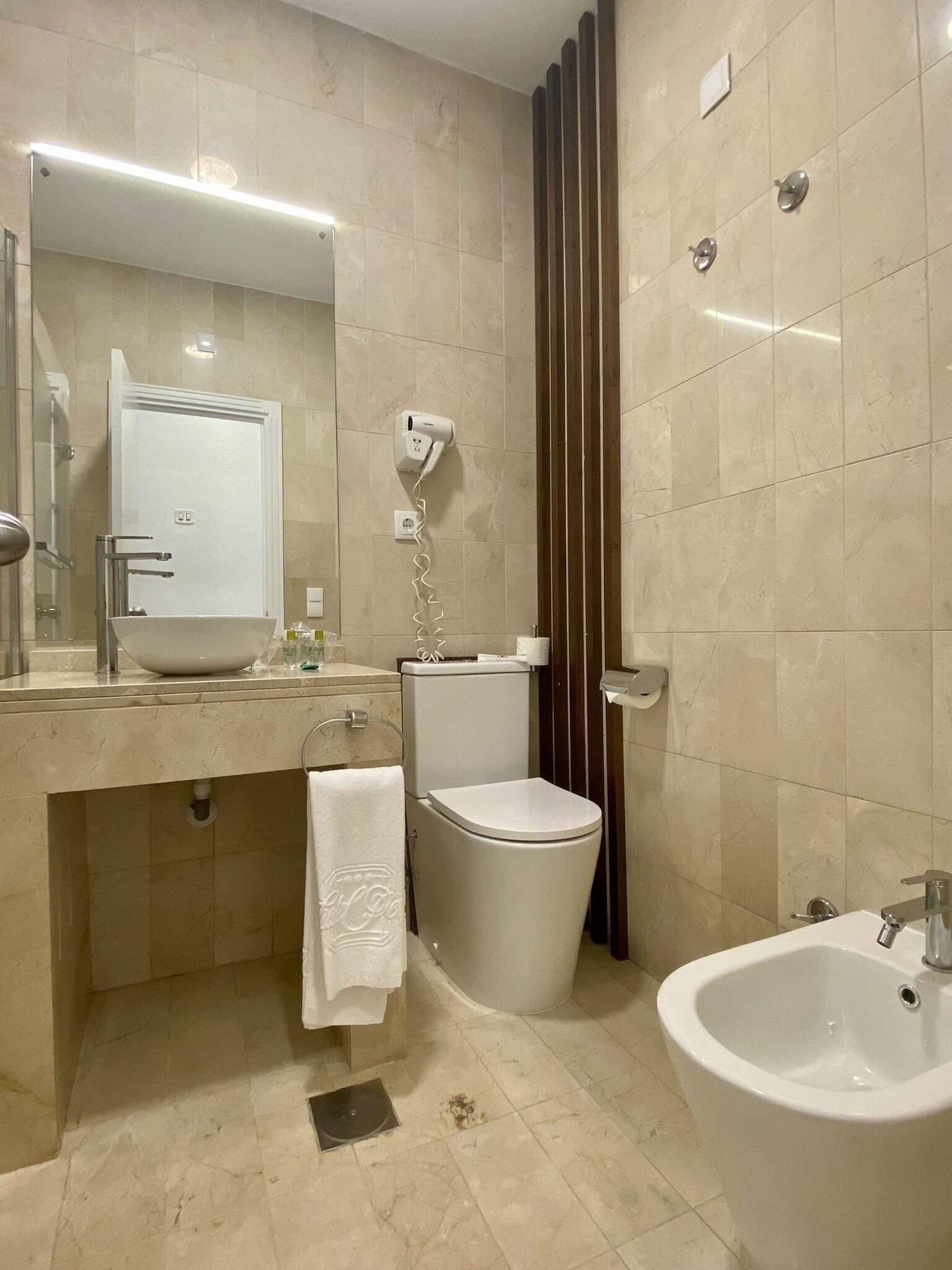 A modern bathroom with a sink, toilet, bidet, and bidet seat.