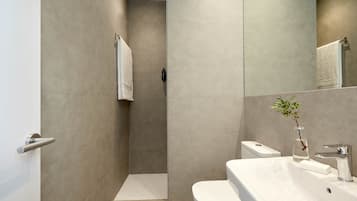 Un baño moderno con ducha, inodoro y lavabo.