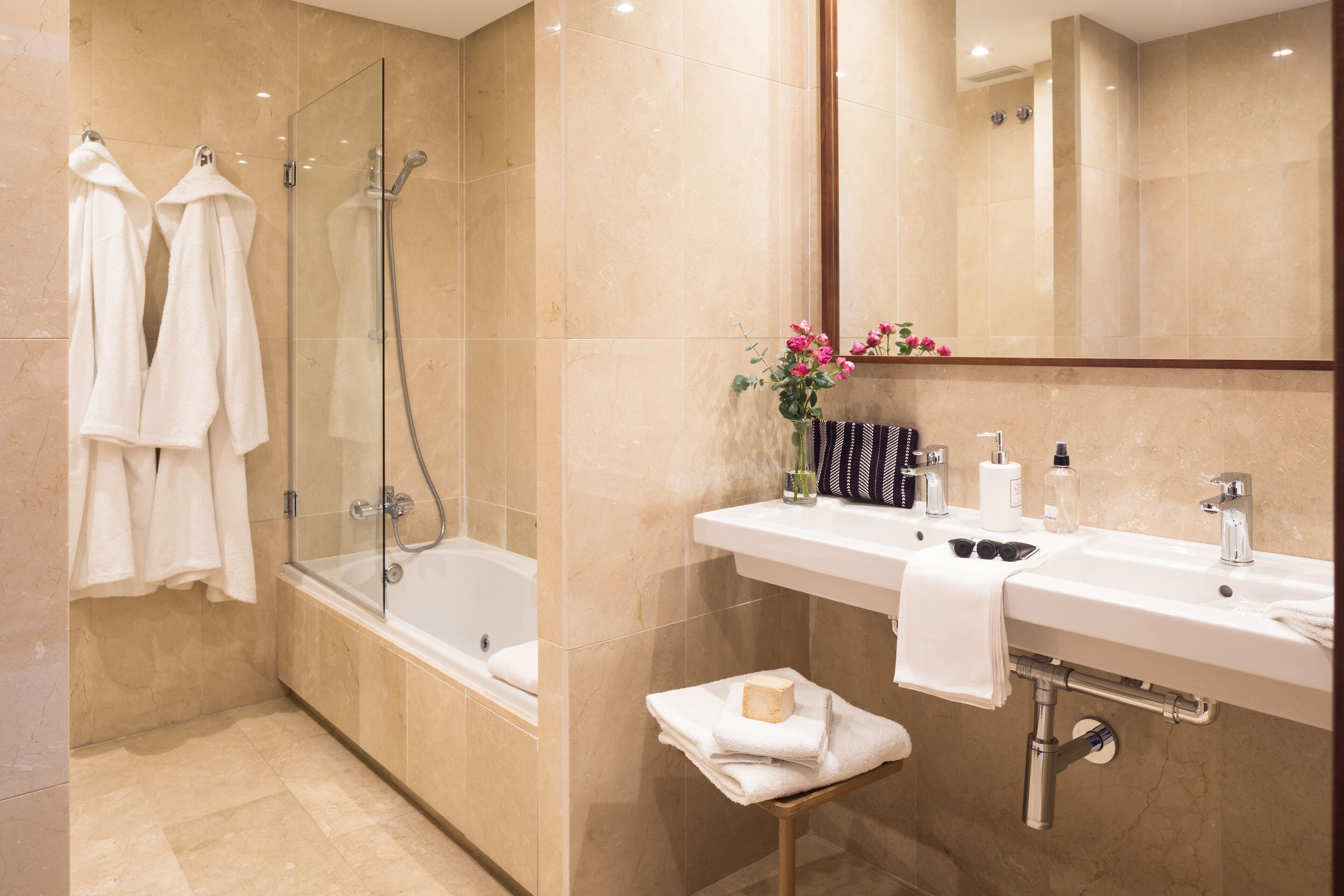 Une salle de bain moderne avec une douche à parois de verre, un meuble-lavabo et un miroir au-dessus du lavabo.
