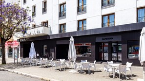 A hotel with outdoor seating, a cafe, and a visible restaurant. - Virgen de los Reyes Hotel (Seville)