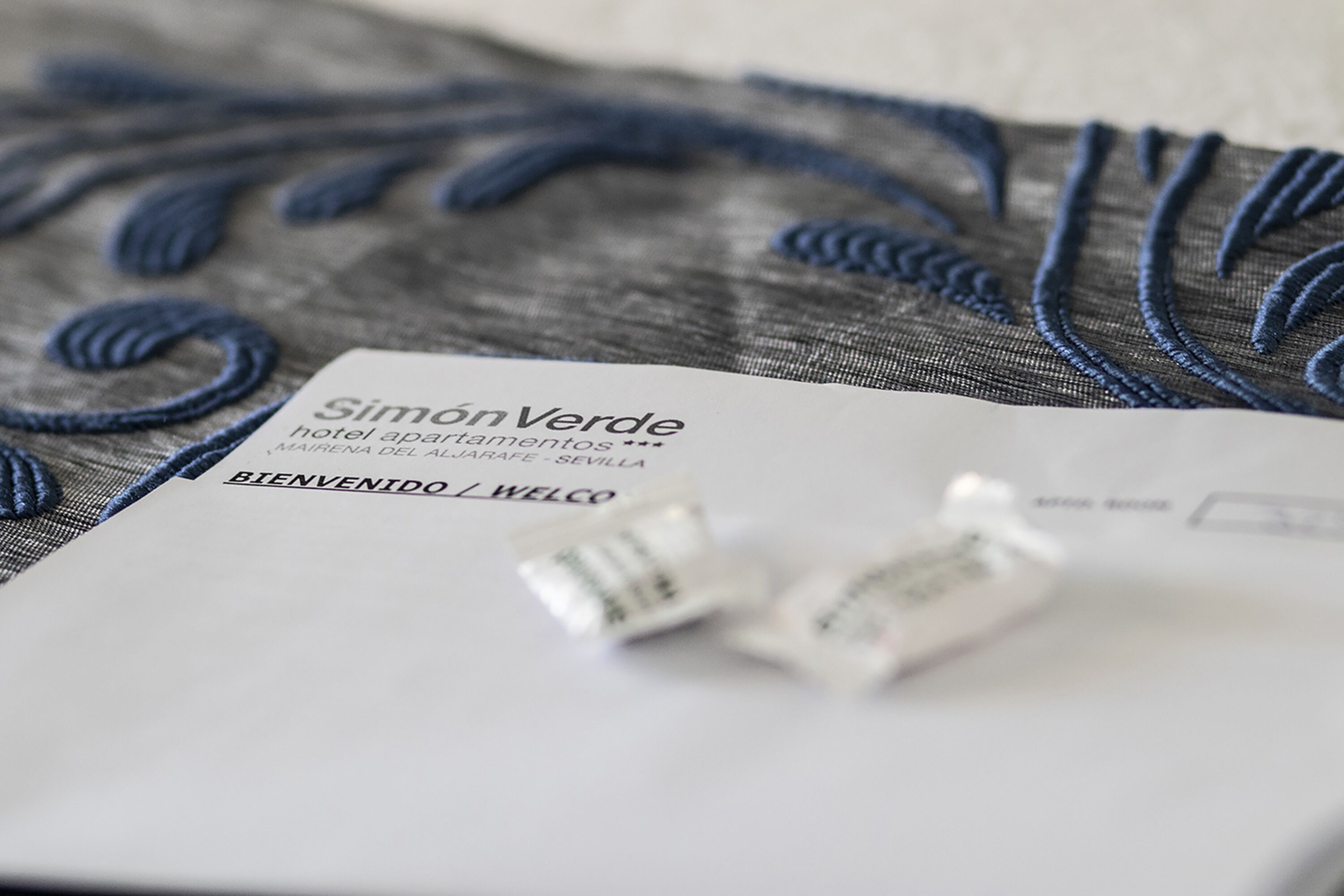 A hotel welcome card with the name 'Simon Verde' and a 'BIENVENIDO / WELCOME' message.