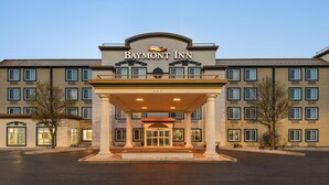 A hotel entrance with a covered lobby, multiple windows, and a prominent signage. - Baymont by Wyndham Rockford (Rockford)