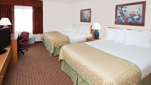 A hotel room with two beds, a desk with a television, a chair, and two lamps. - Baymont by Wyndham St. Joseph/Stevensville (Stevensville)