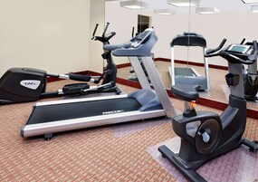 A hotel gym with treadmills, an elliptical, and a stationary bike.