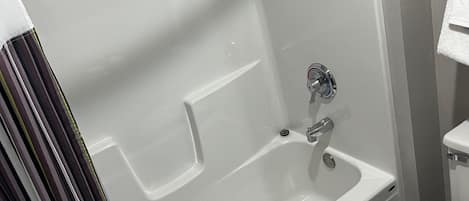 Un baño moderno con bañera, inodoro y zona de ducha.