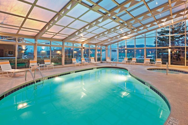 Una piscina techada, sillones reclinables de piscina
