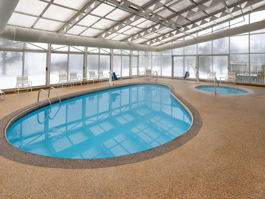 Una piscina cubierta, tumbonas