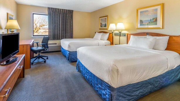 A hotel room with two beds, a desk with a TV, a chair, and two lamps. - La Quinta Inn & Suites by Wyndham Las Cruces Organ Mountain (Las Cruces)