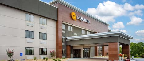 A modern hotel with a prominent 'La Quinta' sign, a covered entrance, and a parking lot.