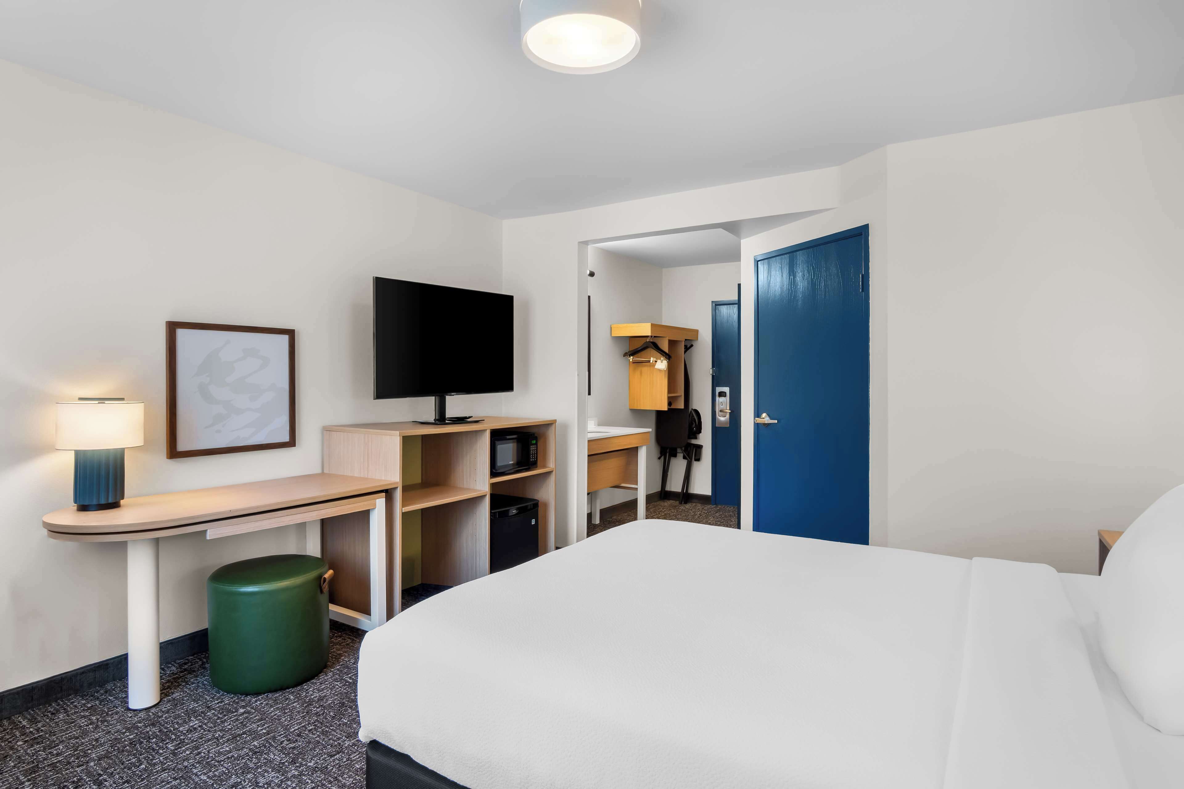 room, 1 queen bed, roll-in shower | desk, laptop workspace, iron/ironing board, free rollaway beds