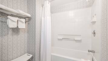 Un baño con ducha, inodoro y un perchero para toallas.