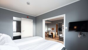 A hotel room with a large bed, a desk, a chair, a TV, and a bathroom visible through an open door. - Scandic Vadsø (Vadsø)