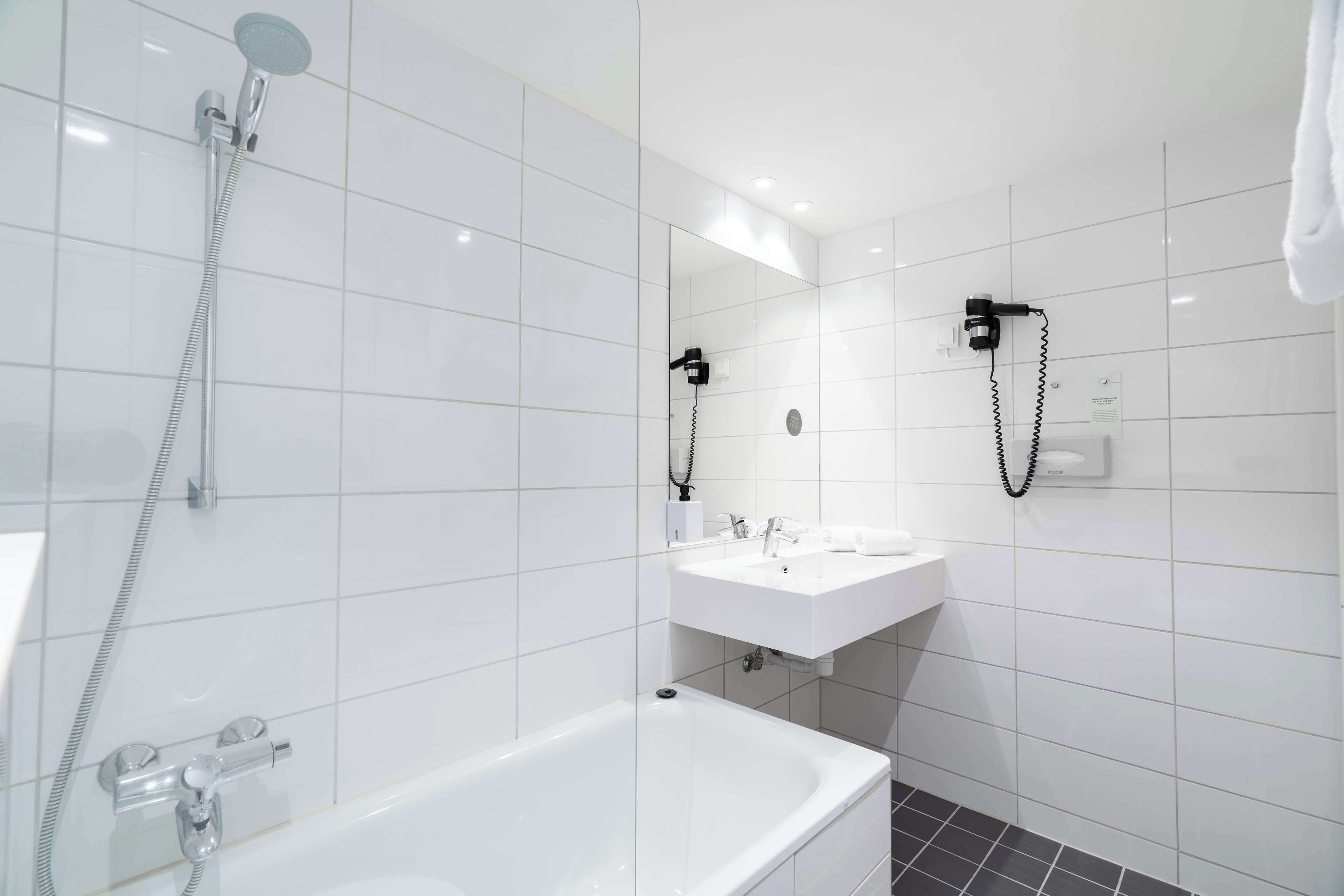 A modern bathroom with a bathtub, a shower, and a sink.